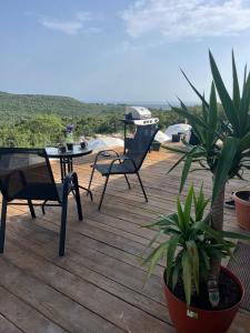 a wooden deck with chairs and a table and plants at Glamping ROSE (Luštica Bay) in Radovići