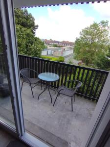 Un patio con una mesa y sillas en un balcón. en Appt cosy 2 pièces proche gare, en Templemars