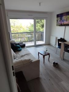 una sala de estar con un sofá y una mesa en Appt cosy 2 pièces proche gare, en Templemars