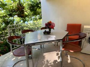 a table with chairs and a vase of flowers on it at Uzeiri’s Houses in Borsh