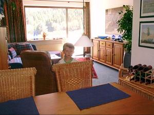 a little boy sitting in a chair in a living room at Fewo Corell in Willingen