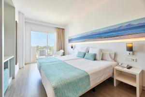 a hotel room with a large bed and a window at AluaSun Continental Park Hotel & Apartments in Playa de Muro