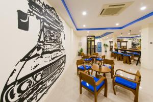 a restaurant with a large painting of a ship on the wall at The Pho Thong Phuket in Phuket