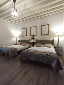 a room with two beds and two tables in it at Casa Mayor in Huérmeces