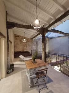 a patio with a wooden table and a chandelier at Casa Mayor in Huérmeces