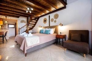 a bedroom with a large bed and a chair at Stone House Maria in Skala Marion +84 photos