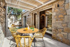 an outdoor patio with a wooden table and chairs at Stone House Maria in Skala Marion