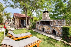 a patio with a stone fireplace in a yard at Stone House Maria in Skala Marion
