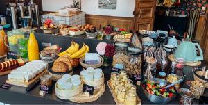 een tafel gevuld met veel verschillende soorten voedsel bij Hôtel Le Manoir in Marche-en-Famenne