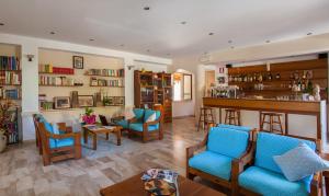 ein Wohnzimmer mit Bar, Stühlen und Bücherregalen in der Unterkunft Hotel Sandalyon in San Teodoro