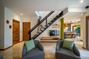 a living room with two chairs and a staircase at Villa Artisane in Seminyak