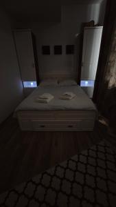 a bed in a room with two cabinets and a bedvisor at Luxury ap 2 rooms - AB House in Lunca Cetăţuii