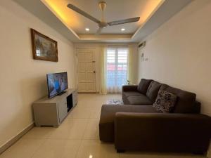 a living room with a couch and a flat screen tv at SIREH Cozy Homestay Jln Garuda TelokPanglimaGarang in Teluk Panglima Garang