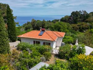 une petite maison blanche avec un toit orange dans l'établissement casa panoramica bouganville, à SantʼAndrea
