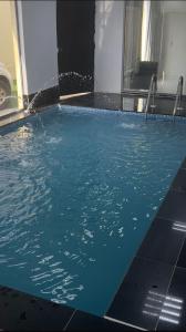 ein Pool mit blauem Wasser in einem Gebäude in der Unterkunft شاليهات هابي بارك 2 in Ukaz