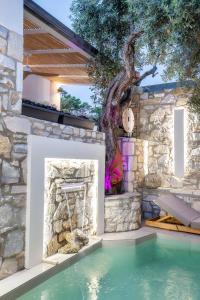an outdoor pool with a tree in the background at Stone House Maria in Skala Marion