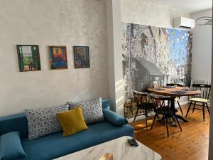 a living room with a blue couch and a table at Diva Kapana 2BDR Apartment with parking in Plovdiv