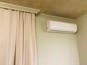 a room with a curtain and a air conditioner at Sweet Lemon in Batumi