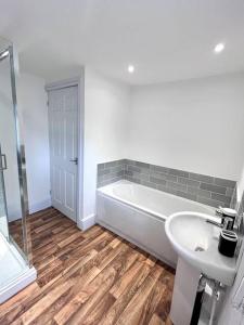 ein weißes Badezimmer mit einer Badewanne und einem Waschbecken in der Unterkunft Outdoor Patio, Near Stadium Of Light, Refurbished in Monkwearmouth