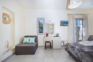 a bedroom with a bed and a chair and a desk at Erato Hotel in Agia Marina Aegina