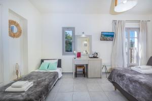 a bedroom with two beds and a desk in it at Erato Hotel in Agia Marina Aegina