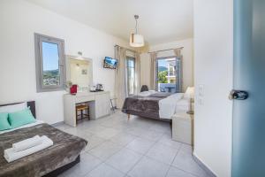 a hotel room with two beds and a desk and a bed at Erato Hotel in Agia Marina Aegina