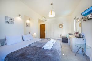a bedroom with a large bed and a living room at Erato Hotel in Agia Marina Aegina