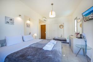 a bedroom with a large bed and a table at Erato Hotel in Agia Marina Aegina