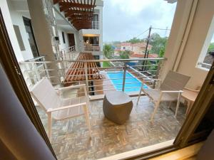 a view of a balcony with chairs and a pool at Seashells Apartment - Grand Baie in Grand-Baie