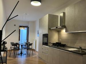 a kitchen with a table and chairs and a kitchen with a stove at In Media Urbe NEXT in LʼAquila