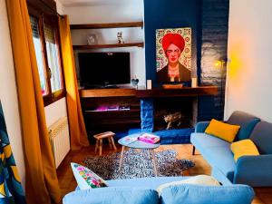 a living room with a blue couch and a fireplace at Cal Jan HUT6-8208 in Aixovall