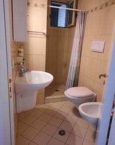 a bathroom with a sink and a toilet and a shower at Himara Sea Sunny Home in Himare