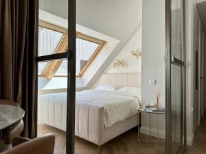 a bedroom with a bed and a window at White Penthouse Juodkrante in Juodkrantė