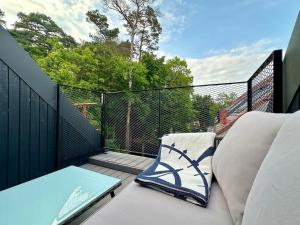 a balcony with a couch and a table on a balcony at White Penthouse Juodkrante in Juodkrantė