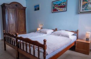 a bedroom with a large bed with a wooden headboard at Apartments Hinterreiter in Rovinj