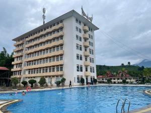 a hotel with a swimming pool in front of a building at Muong Thanh Lai Chau Hotel in Pan Linh