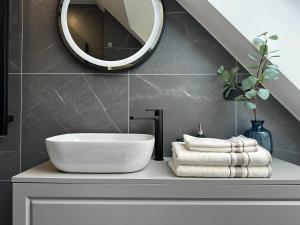 a bathroom with a sink and a mirror and towels at White Penthouse Juodkrante in Juodkrantė +8 photos