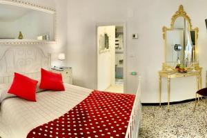 a bedroom with a large white bed with red pillows at Casetta Ambretta in Monterosso al Mare