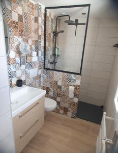 Un baño con lavabo, inodoro y espejo. en "Carpe diem" Charmante maison CDG-RER B-Parc des expos de Villepinte-Astérix-Stade de france, en Villeneuve-sous-Dammartin 23 fotos más