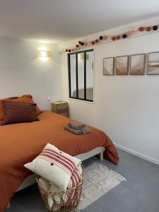 a bedroom with a large bed and a window at Les Maisons d'Auré: Le studio in Putanges
