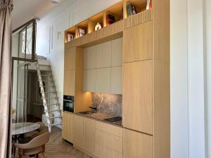 a kitchen with a large wooden cabinet with a sink at White Penthouse Juodkrante in Juodkrantė