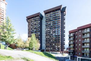 a tall apartment building in front of a street at Les Cimes du Corbier - Proche des stations de ski in Villarembert