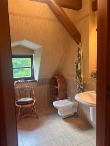 La salle de bains est pourvue d'un lavabo, de toilettes et d'une chaise. dans l'établissement Sauna House Smyczyna, à Smyczyna
