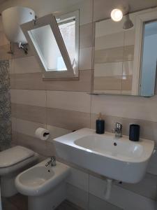 a bathroom with a sink and a toilet and a mirror at Casa Margherita in Ponza +24 photos