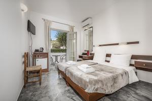 a hotel room with a bed and a balcony at Erato Hotel in Agia Marina Aegina