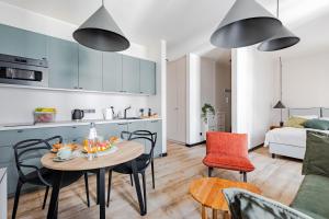 a kitchen and a living room with a table and chairs at Mińska Apartament in Warsaw