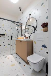 a bathroom with a toilet and a rock wall at Mińska Apartament in Warsaw +6 photos