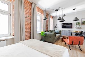 a room with a bed and a brick wall at Mińska Apartament in Warsaw