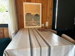 a table in a room with a picture on the wall at Casa Leo in Gujan-Mestras