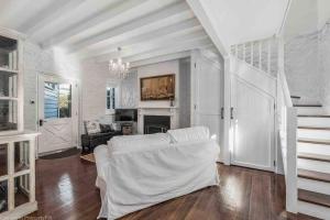 a living room with a white couch and a staircase at Warm, Inviting & Luxurious The Barn in Sandy Bay
